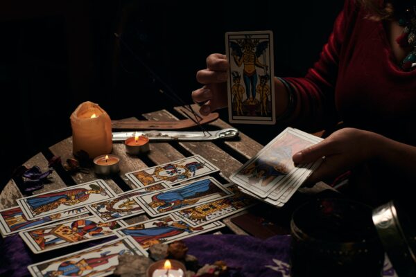 Pythoness reads tarot cards in a dark environment